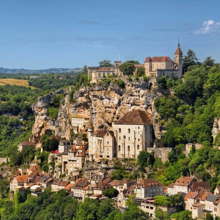 Medieval village of Rocamadour clinging to a cliff face, with a castle and church at the top.