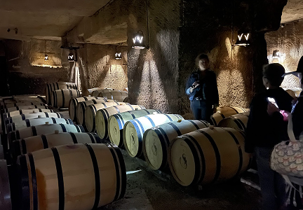 Oak wine barrels aging in an underground limestone cellar in Saint-Émilion