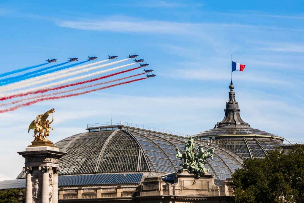 Jets flying in formation over Grand Palais with blue, white, red smoke trails
