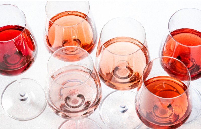 Glasses of Provence rosé in shades from pale pink to salmon on a bright white background