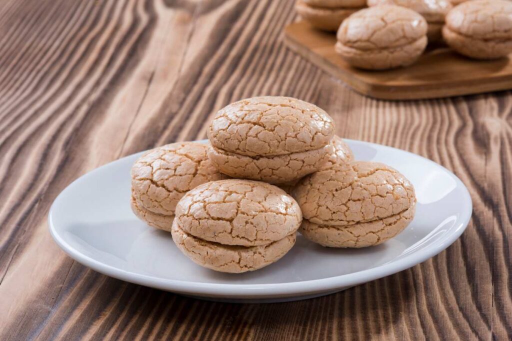 Traditional round almond cookies of St Emilion on a white plate on a wooden tabletop